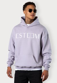 Lavender hoodie made of soft fabric, featuring a front kangaroo pocket, ribbed cuffs, and bold "ESTEEM" print in white.
