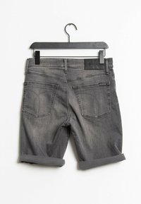 Grijze denim shorts met opgerolde cuffs en twee achterzakken. Heeft een zwart leren label op de tailleband en subtiele stikdetails.