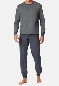 Sweatshirt gris à motifs avec un design texturé, poignets côtelés, associé à un pantalon de jogging gris foncé assorti avec taille élastique et poignets.