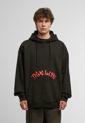 Černá mikina s kapucí, přední kapsou, šňůrkou na kapuci a výrazným červeným grafickým nápisem "THUG LIFE" na přední straně ve stylizovaném písmu.