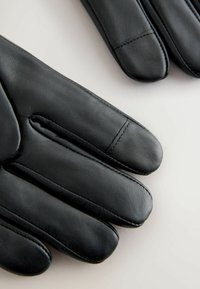 Black leather gloves featuring a smooth texture, sleek design, and prominent stitching along the fingers, with a slightly rounded tip on each finger.