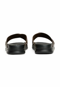 Sandali in gomma marrone con suola nera, dotati di due cinturini curvi e una soletta testurizzata per il comfort. Design pulito con dettagli minimi.