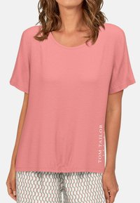 Lichtroze kortetermijn t-shirt met een ronde hals. Bevat het "TOM TAILOR" logo in het wit aan de linkerkant. Gladde stoftextuur.
