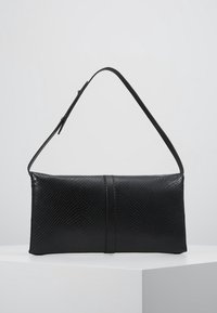 Černá obdélníková kabelka s texturovaným koženým povrchem a jedním ramenním popruhem, vystavená na jednoduchém světlem pozadí na bílém podstavci.