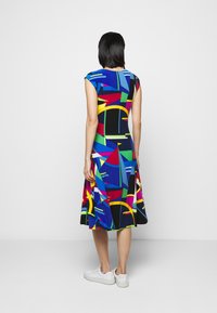 Multi-colored knee-length dress with a fitted top and flared skirt, featuring geometric patterns in blue, green, red, and yellow.
