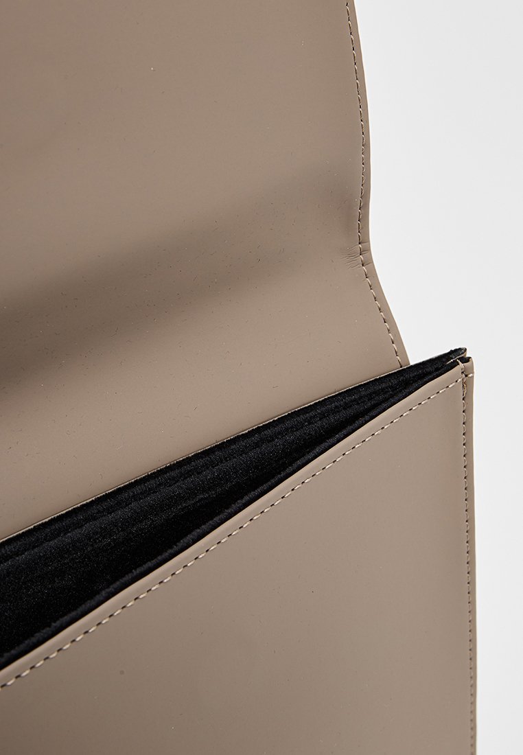 Portafoglio in pelle beige aperto, che mostra l'interno in tessuto nero e la cucitura dettagliata lungo i bordi.