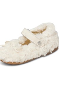 Scarpa per bambini di colore crema morbido, con una texture in peluche riccio, una cinghia in pelle con un bottone a forma di stella e un piccolo fiocco decorativo sulla punta.