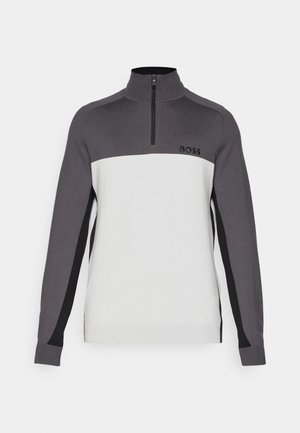 Zip-up sweatshirt with a high collar, featuring a gray upper and white lower section, textured fabric, and black accents on sleeves. Logo included.