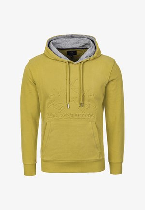 Žlutá mikina s kapucí a šedým vnitřkem, která na přední straně obsahuje texturované logo a grafický design. Zahrnuje přední kapsu a šňůrky.