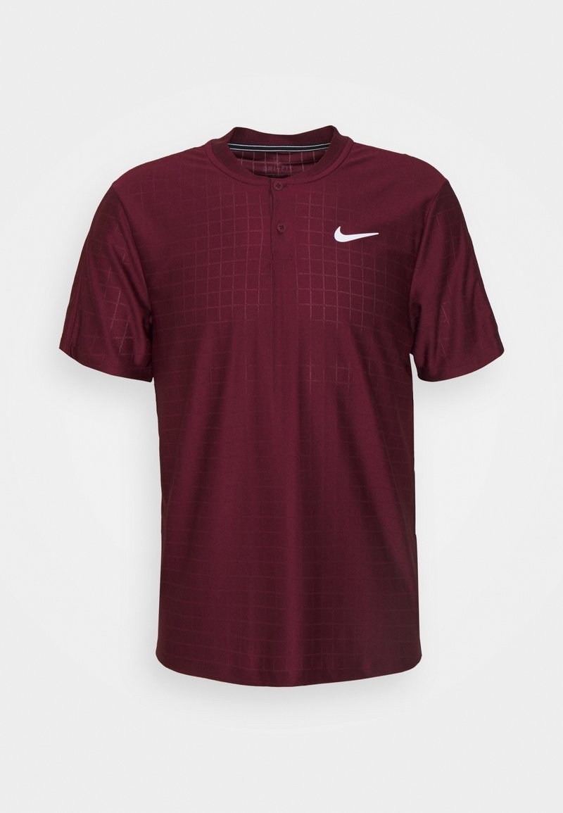 Camisa polo corta de color marrón con un patrón de cuadrícula y tapeta de botones; presenta un logo de Nike en blanco en la parte superior izquierda.