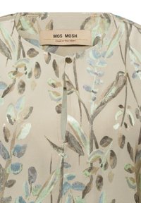 Hellbeige Bluse mit rundem Ausschnitt und einem Schlitz an der Vorderseite. Sie hat ein florales Muster in sanften Grüntönen und metallischen Akzenten. Marke: MOS MOSH.