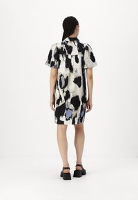 Rochie cu mânecă scurtă, cu un print abstract multicolor care include negru, crem și albastru deschis. Prezintă o croială lejeră și o linie a tivului dreaptă.