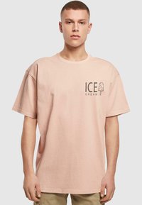 Light pink cotton t-shirt with short sleeves, featuring a graphic logo of a popsicle and the text "ICE CREAM" on the left side.