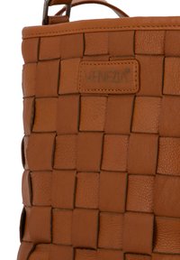 Sac à main en cuir tressé marron avec des motifs carrés et un éclat subtil. Dispose d'un bord cousu et d'un logo "VENEZIA" embossé sur le devant.
