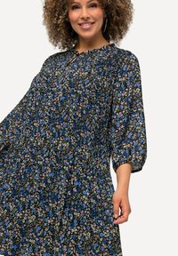 Floral dress with black background, featuring blue and pink flowers, smocked bodice, and three-quarter puff sleeves.