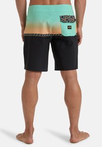Shorts de bain en dégradé teal passant au noir, avec une poche à motifs et des coutures contrastées. Fabriqué en matériau léger et à séchage rapide.