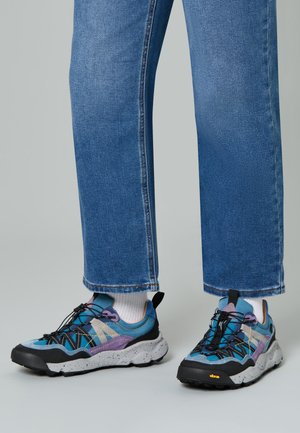 Des baskets multicolores avec une tige en mesh et en synthétique, présentant des accents bleus, violets et gris ; semelle extérieure en caoutchouc noir avec un profil texturé.