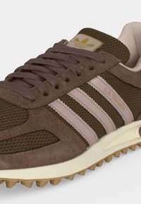 Baskets Adidas LA Trainer marron avec des bandes roses, tige en suède et mesh, languette siglée, et semelle épaisse crème avec semelle en gomme.