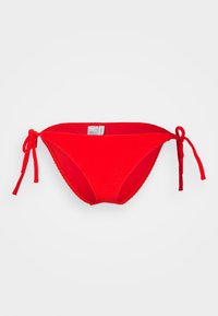 Červené bikini spodky s viazaním po stranách, hladkou textúrou a kontrastným šitím. Majú nízky strih a minimálne krytie.