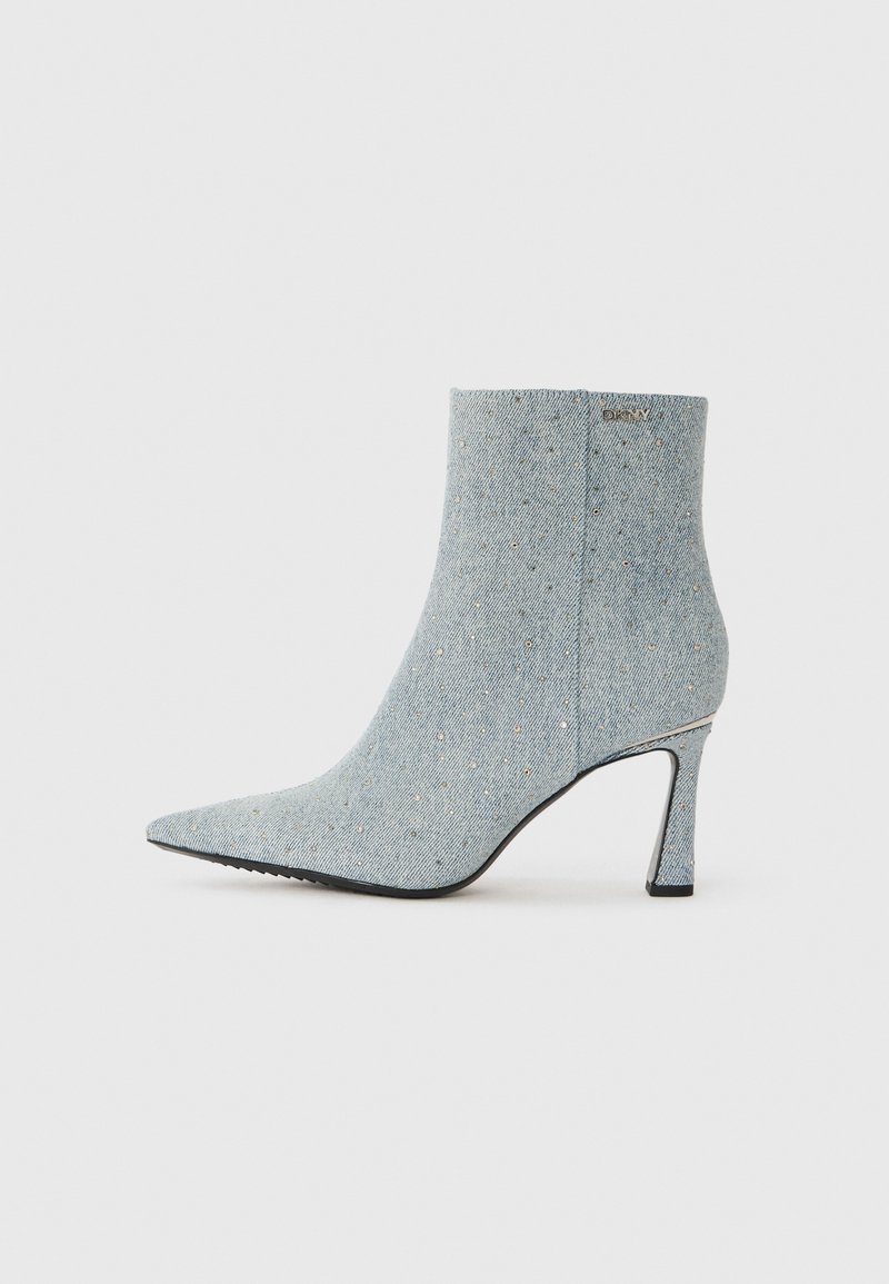 Stivaletto in denim con punta affusolata, color blu chiaro, e decorato con piccole borchie argentate. Presenta un tacco a spillo e un tessuto strutturato.