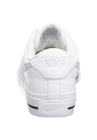 Valkoiset Nike-tossut nahkapäällisellä, teksturoidulla kantapäällä ja kumipohjalla. Ominaisuuksiin kuuluu huomaamaton brändäys kantapään ja välikannan osalta. Korostettu violetilla.