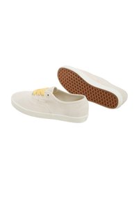Beige suede sneakers with yellow laces, white rubber midsoles, and brown textured outsoles, featuring a low-cut design.