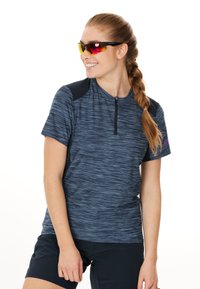 Kortärmad, blå atletisk tröja med dragkedja i kragen, med texturerad tyg och svarta axelaccenter. Bärs med reflexglasögon.