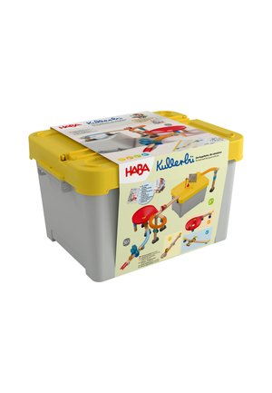 Szare i żółte plastikowe pudełko do przechowywania z opakowaniem zestawu zabawek toru kulkowego HABA Kullerbü owiniętym wokół niego.
