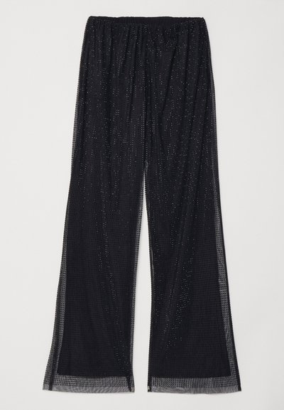 Pantaloni negri cu picioare largi, confecționați dintr-un material texturat, având o strat fin cu puncte reflectorizante și un bretele elastic pentru confort.