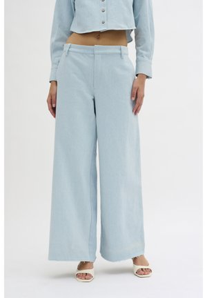 Pantalones anchos de talle alto en azul claro, confeccionados en un tejido suave de mezclilla. Presentan una textura lisa y un dobladillo deshilachado en los tobillos como detalle.