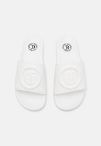 Sandale albe cu talpă plată, prezentând o bandă superioară texturată cu un logo circular ridicat și un picior neted. Design simplu și discret.