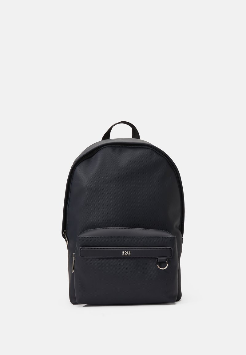 Mochila azul marino fabricada en nylon texturizado, con un compartimento principal con cremallera, un bolsillo frontal con cremallera y una asa en la parte superior para llevar.