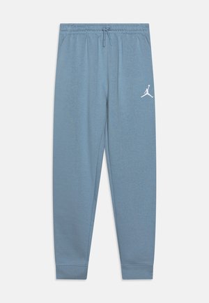 Pantalones de chándal azul claro, hechos de una tela suave, con cintura ajustable mediante cordón y un logo Jumpman blanco en la pierna izquierda. Corte estándar con puños acanalados.