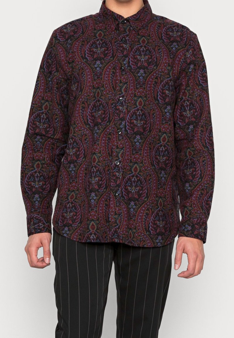 Long-sleeve button-up shirt in dark fabric featuring a paisley pattern in red, purple, and green hues. Black buttons and adjustable cuffs.
