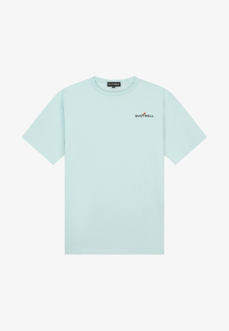 Camiseta de algodón azul claro con mangas cortas, escote redondo y un logotipo negro de "QUOTRELL" acentuado por un elemento de diseño rojo.
