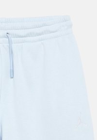 Ανοιχτό μπλε φόρμας με ελαστική μέση και κορδόνι, με διακριτικό λευκό λογότυπο Jumpman στο πάνω μέρος του μηρού.