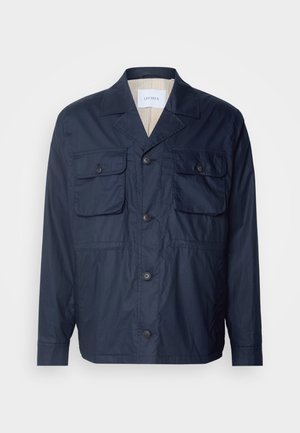 Giacca leggera di colore blu navy con due tasche frontali, chiusura a bottone e fodera interna a righe. Presenta un colletto classico e una vestibilità comoda.