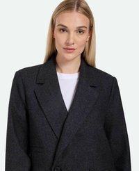Temno siva herringbone blazer s dvojnim zapenjanjem, velikimi klapnicami in dvema sprednjima žepoma. Gladka tekstura tkanine, priložnostna fit.