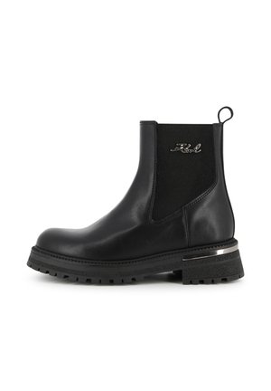 Bottine noire en cuir avec panneau latéral élastique, languette de tirage, semelle épaisse et logo métallique de la marque près du haut.