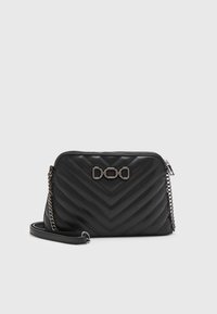 Překládaná černá kožená kabelka přes rameno s chevron vzorem, stříbrným řetízkem a výrazným logem řetězu na přední straně. Uzavírání na zip.