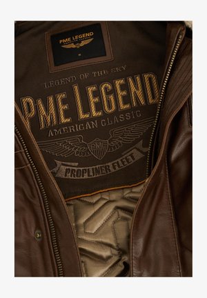 Brauner Lederjacken-Innenraum mit gestepptem Futter. Auffällige Markenstickerei in Gold und Schwarz, mit Flügeln und "PME Legend".