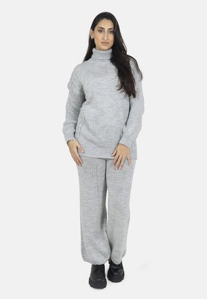 Maglione a collo alto grigio chiaro in maglia con design testurizzato abbinato a pantaloni in maglia grigi a vestibilità ampia e scarpe nere con plateau.