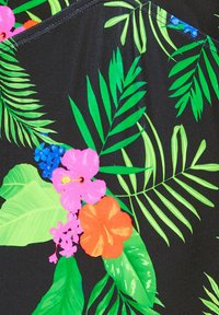 Svart tyg med ett livligt tropiskt mönster med gröna blad och färgglada blommor, inklusive rosa, orange och blå accenter.