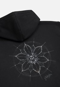 Schwarzer Hoodie mit floralem Design in Weiß und Gold, dazu strahlende Linien und ein zentrales Emblem. Weicher Stoff mit modernem Schnitt.