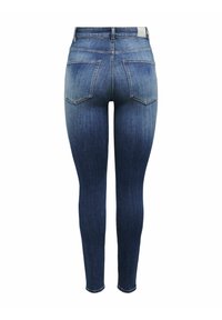 Lieknos džinsinės kelnės, vidutinės mėlynos spalvos, su dėvėtų detalių, penkių kišenių dizainu ir siuvinėtomis užpakalinėmis kišenėmis.