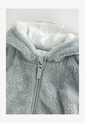 Graue Babykapuze aus weichem, flauschigem Stoff mit glattem Innenfutter, das ein hellblaues Punktmuster aufweist, mit einem durchgehenden Reißverschluss.