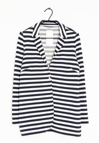 Raitapuku tummansinisenä ja valkoisena, jossa on kaulus, yksittäinen nappikiinnitys ja tikkupussit. Valmistettu teksturoidusta, joustavasta kankaasta.