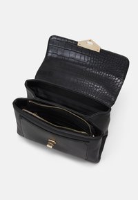 Borsa in pelle nera con un motivo in pelle di coccodrillo testurizzato all'interno. Presenta scomparti con cerniera e una chiusura con gancio dorato.