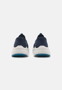 Pantofi sport navy cu superior din plasă texturată, talpă intermediară albă și accente albastre. Design rotunjit cu o bandă la călcâi pentru a fi ușor de încălțat.