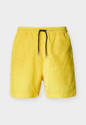 Gule herrebadeshorts med elastisk taljebånd og sort snor, vist mod en ensfarvet lys grå baggrund.